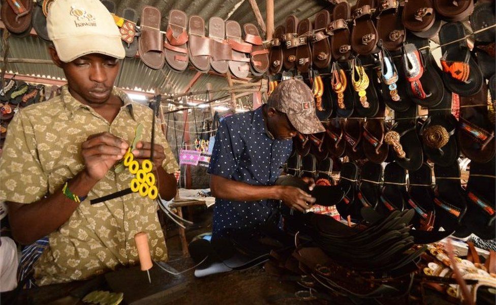 Kenyan men make slippers decorated with beads at the open-air Kariokor market in Nairobi September 20, 2018