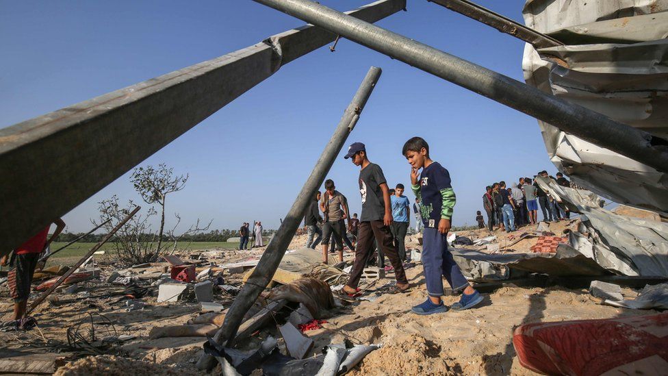 Palestinians inspect the remains of a building following an Israeli air strike in Deir al-Balah, in the southern Gaza Strip (14 November 2019)