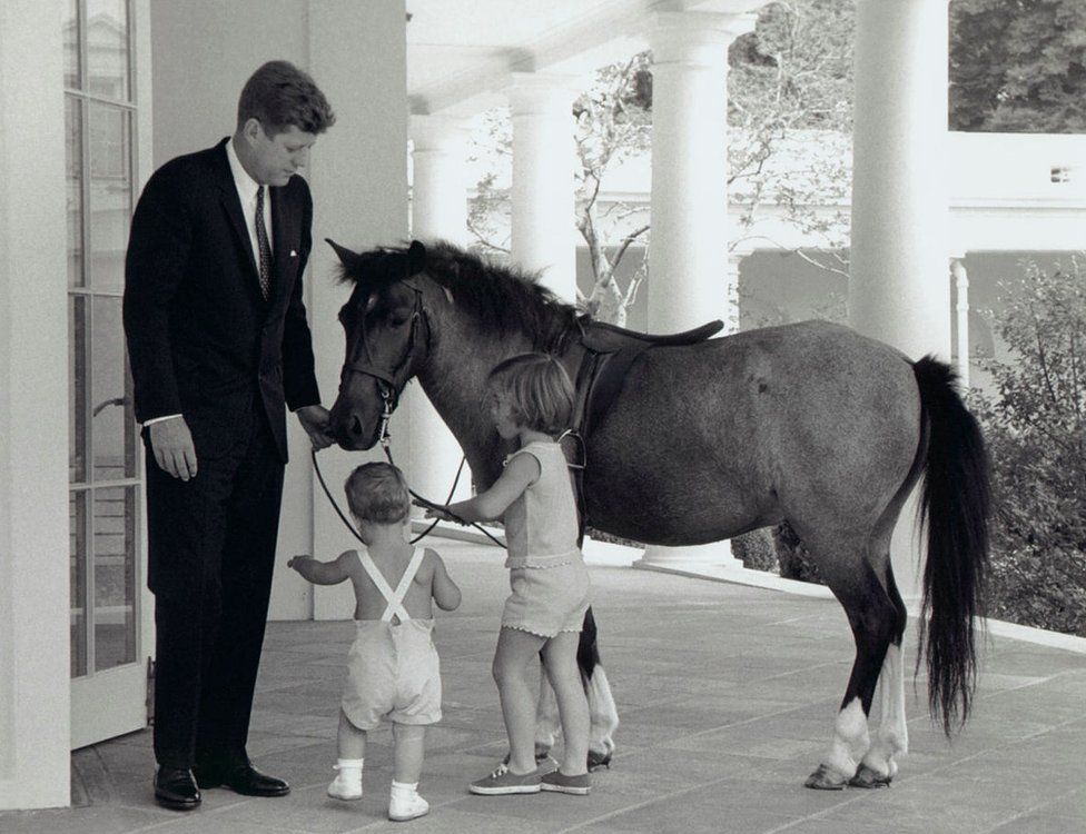 President Kennedy is seen with his daughter Caroline, son John and pet pony Macaroni
