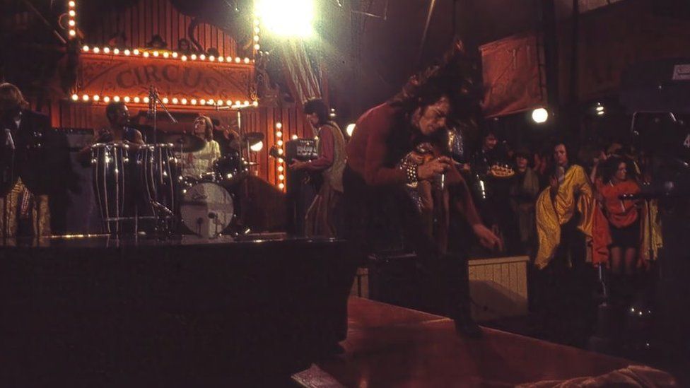 Image showing Mick leaping forward onstage as the band play behind him in 1968