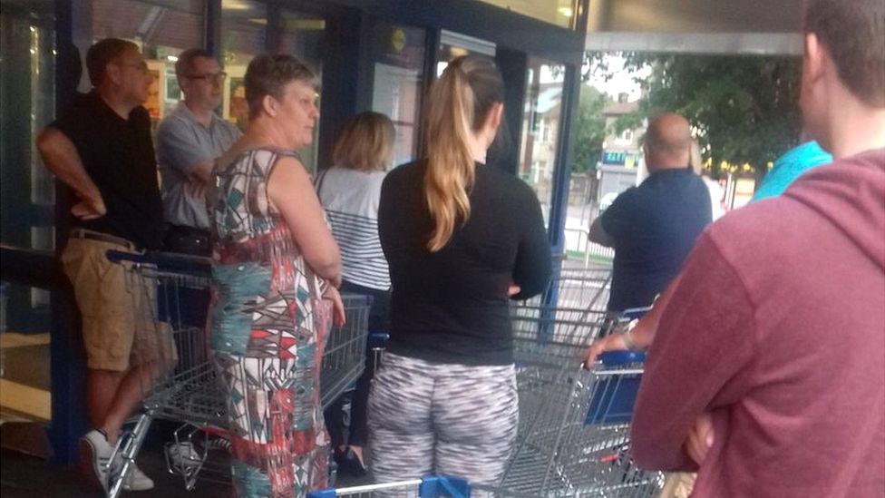 Shoppers queue outside supermarket Lidl for prosecco