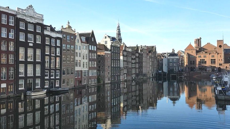 Amsterdam buildings reflected in harbour