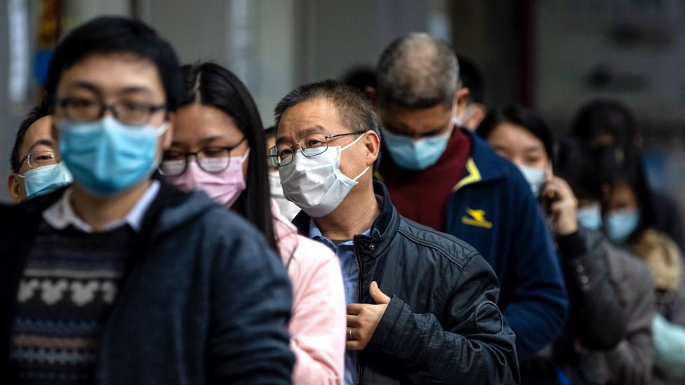 People queue outside a pharmacy as they won the lottery to buy protective masks, in Guangzhou, China, 13 February 2020.