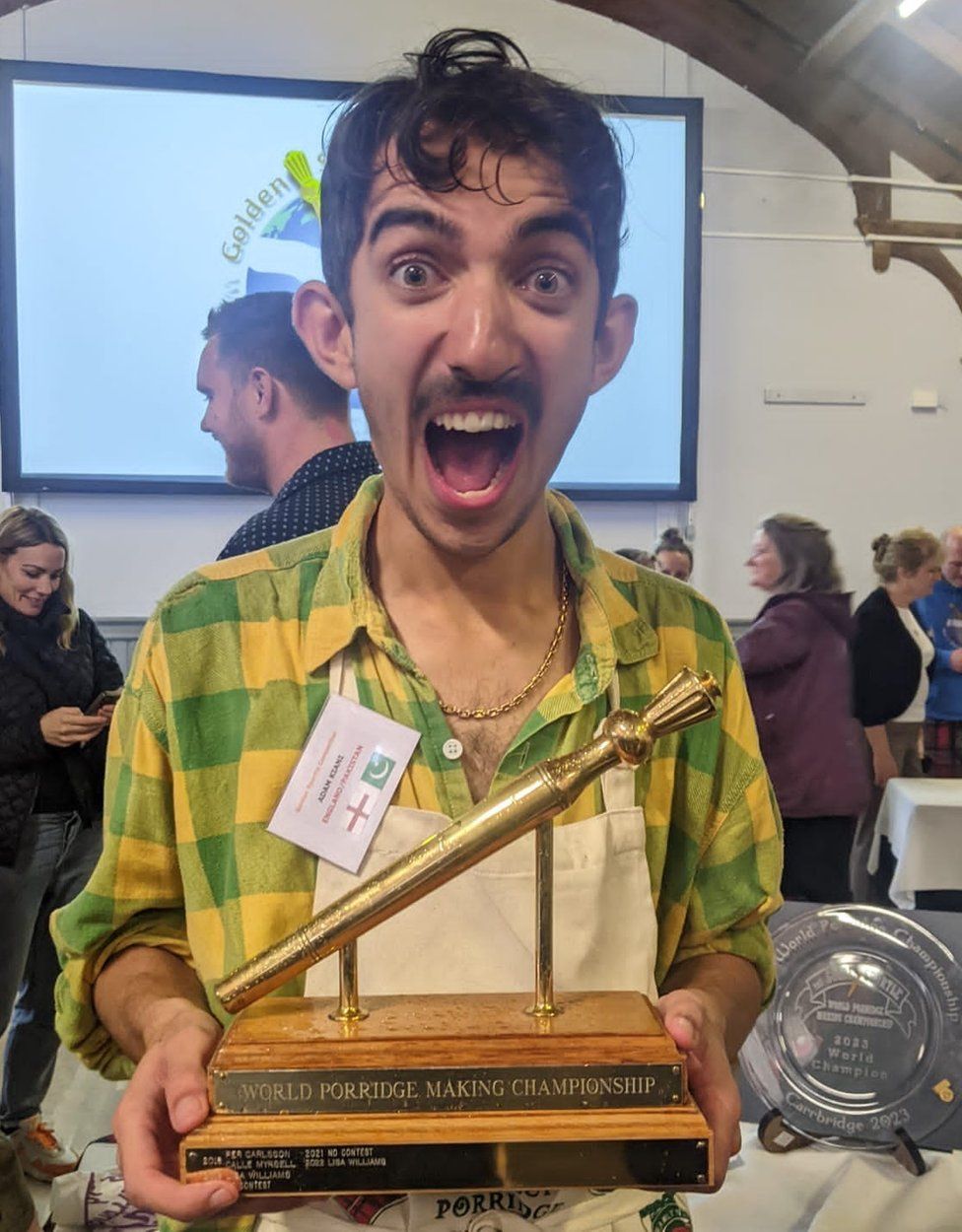 Adam Kiani holding the Golden Spurtle award with a shocked but happy look on his face