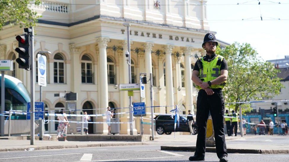 A police officer standing at a crime scene near Nottingham's Theatre Royal.