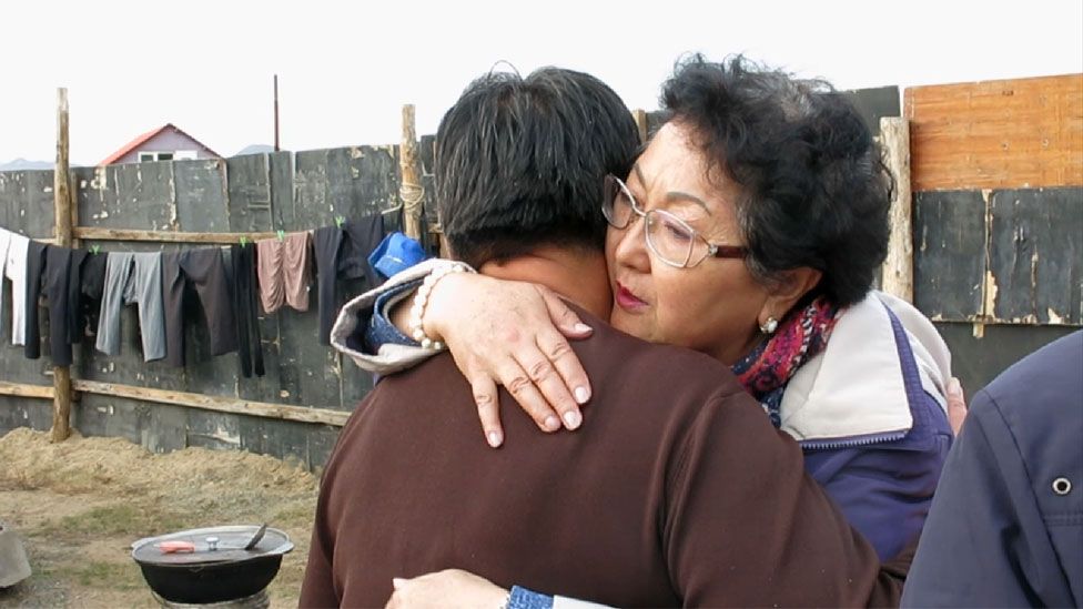 Odontuya Davaasuren comforts Timurbat's wife, Enkjargal