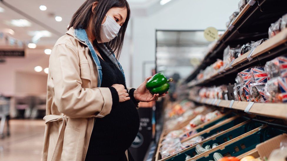Woman shopping for food wearing face mask