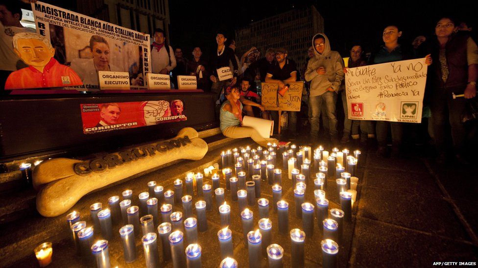 People gathered with banners in front of candles