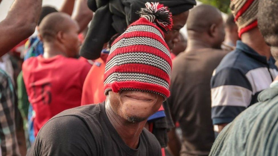 Man with a read woollen hat pulled over his eyes in Arondizuogu during the Ikeji Festival in Nigeria