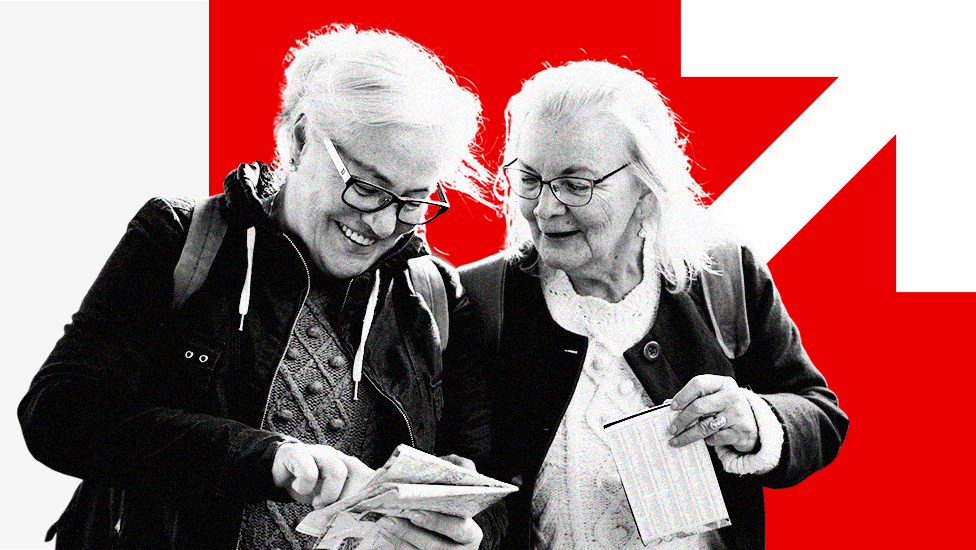 Two older women reading a map