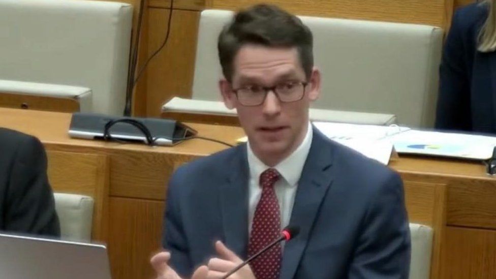 Jonathan Glarum answering questions at Norfolk County Council Scrutiny Committee in March 2023
