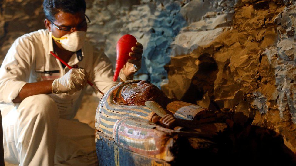 An Egyptian antiquities worker works on a coffin in the recently discovered tomb of Amenemhat, a goldsmith from the New Kingdom, at the Draa Abu-el Naga necropolis near the Nile city of Luxor