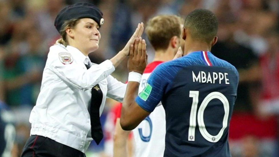 Intruder high-fiving with Mbappé