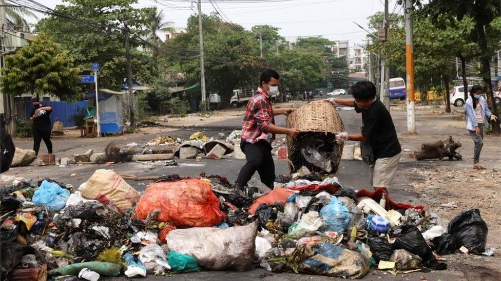 Протестующие против переворота выбрасывают мусор на улицу после того, как активисты нанесли «мусорный удар» против военного режима в Янгоне, Мьянма, 30 марта 2021 года.