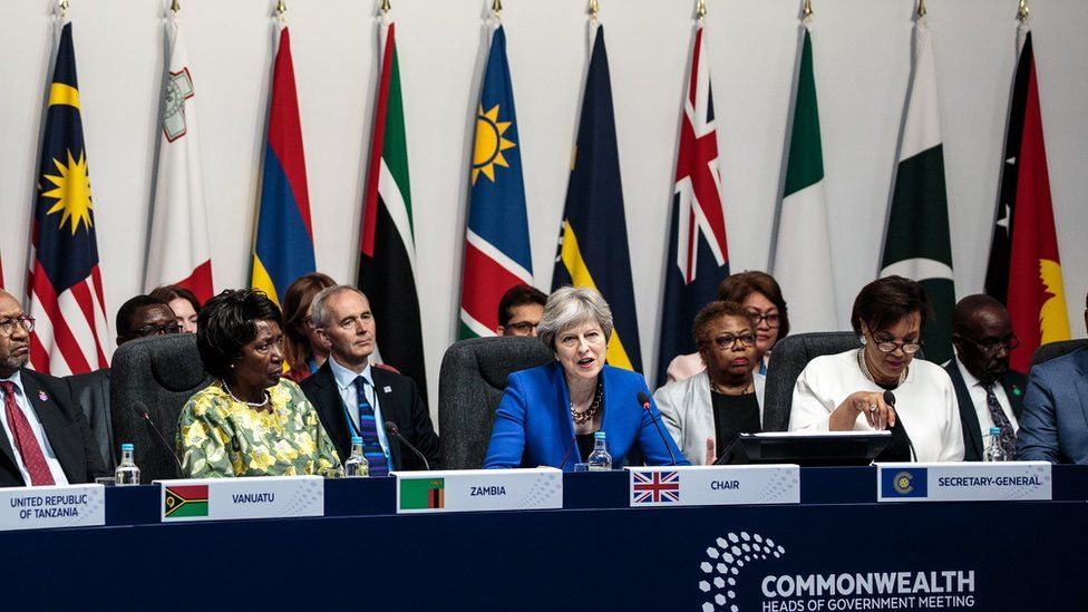Theresa May and other Commonwealth leaders in front of a row of flags
