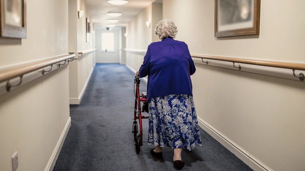 Stock image of a woman in a care home corridor