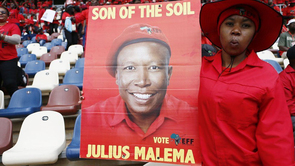 Woman holding a Julius Malema poster