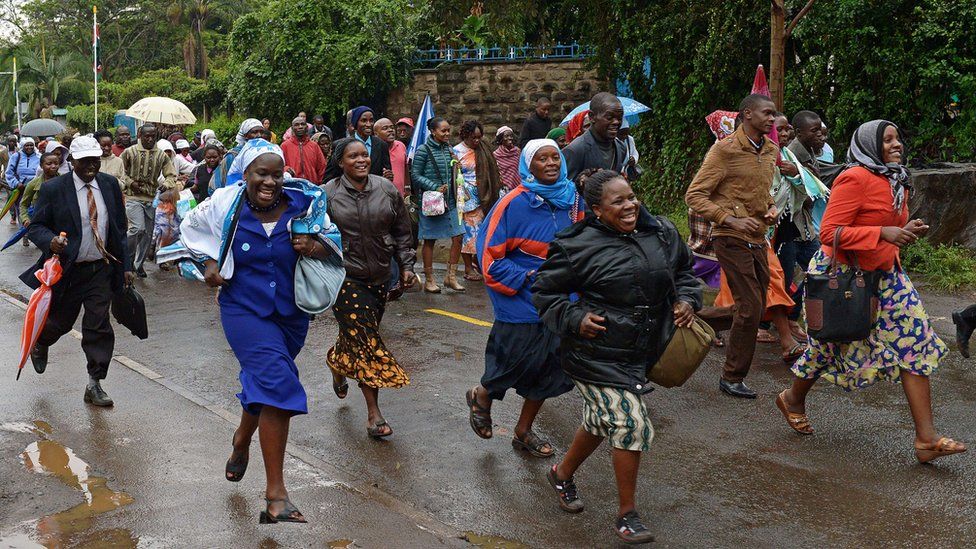 Crowds run to queue in the rain as they wait to access a mass by Pope Francis, during his visit to Africa, on Thursday November 2015