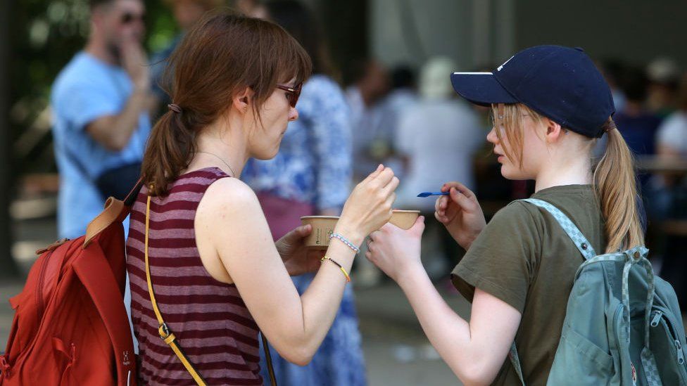 Image shows two people eating ice cream
