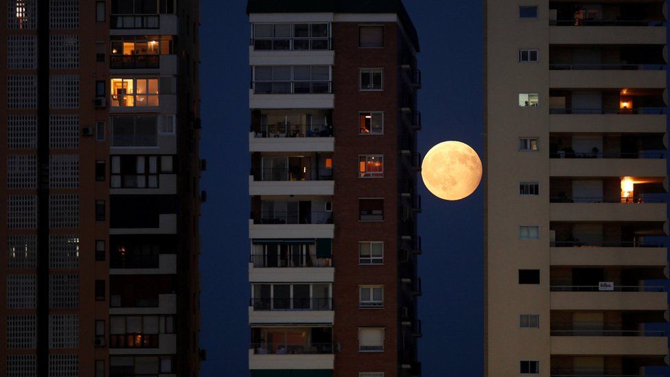 The rising moon is seen during a partial lunar eclipse between buildings in Malaga, southern Spain August 7, 2017.
