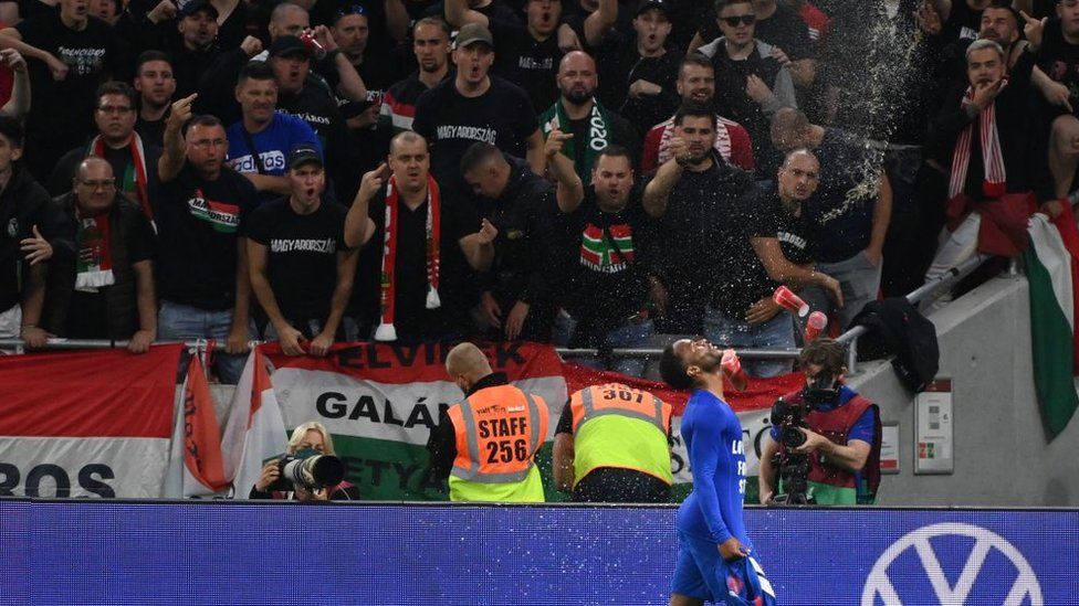 Raheem Sterling celebrating his goal as Hungarian fans gesture angrily