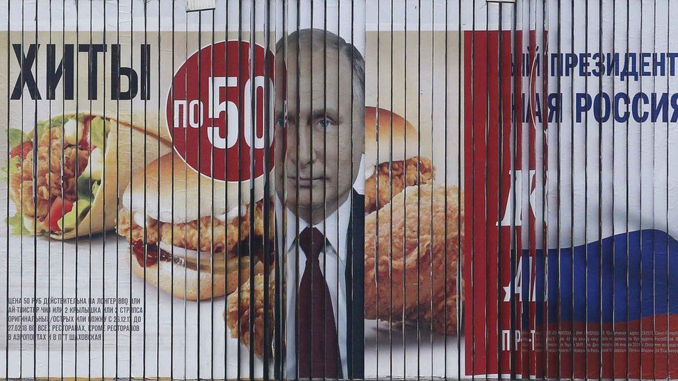 turning billboard displays Putin's face in between fast food adverts