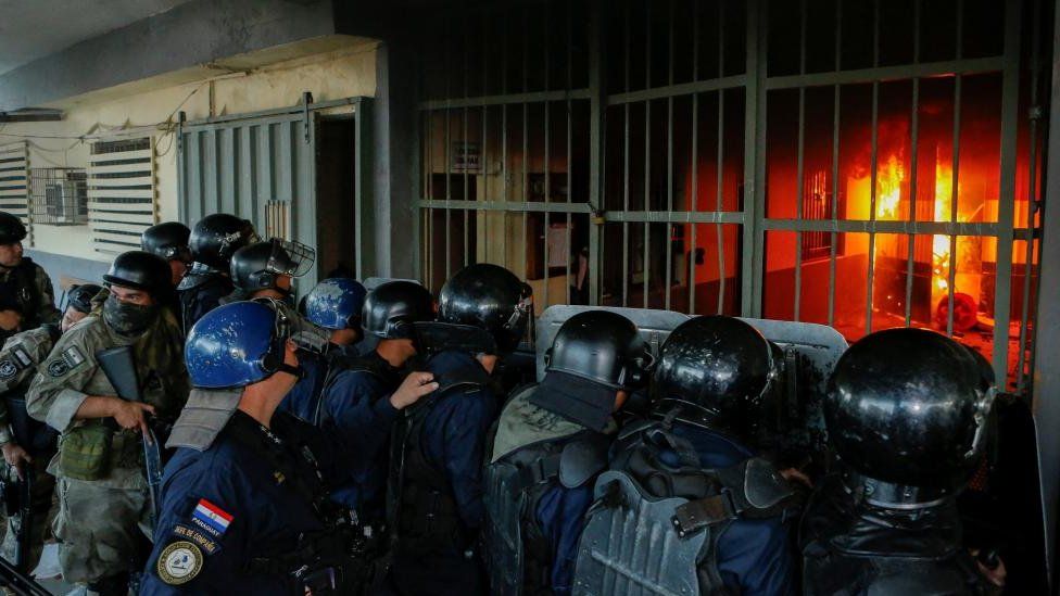 Police stand outside the Tacumbu penitentiary during a riot after inmates took hostage a dozen officials and caused a fire, in Asuncion, Paraguay October 10, 2023.