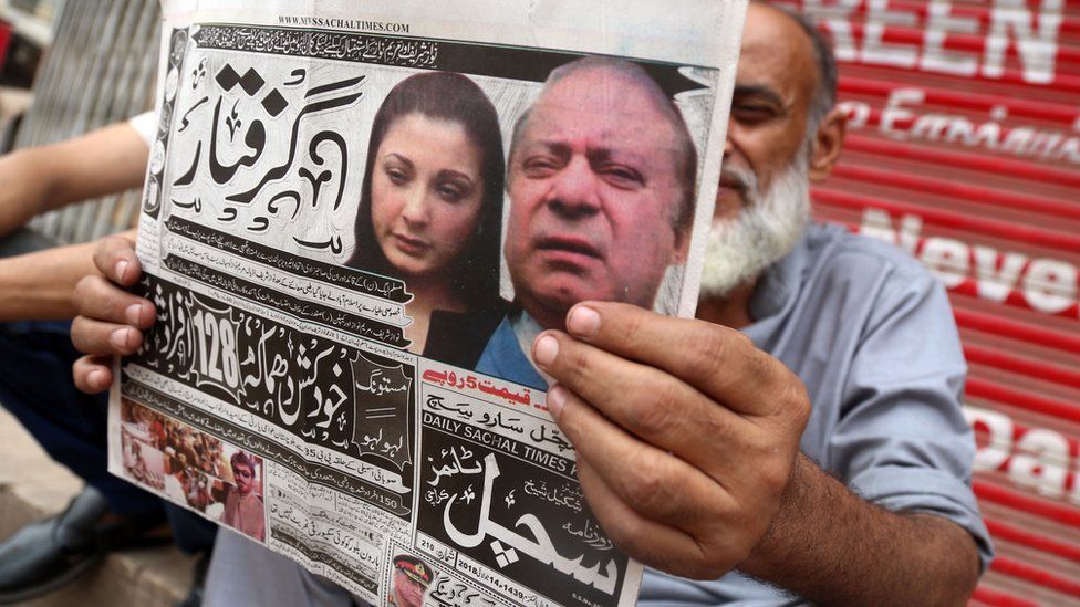 Man holding out a newspaper