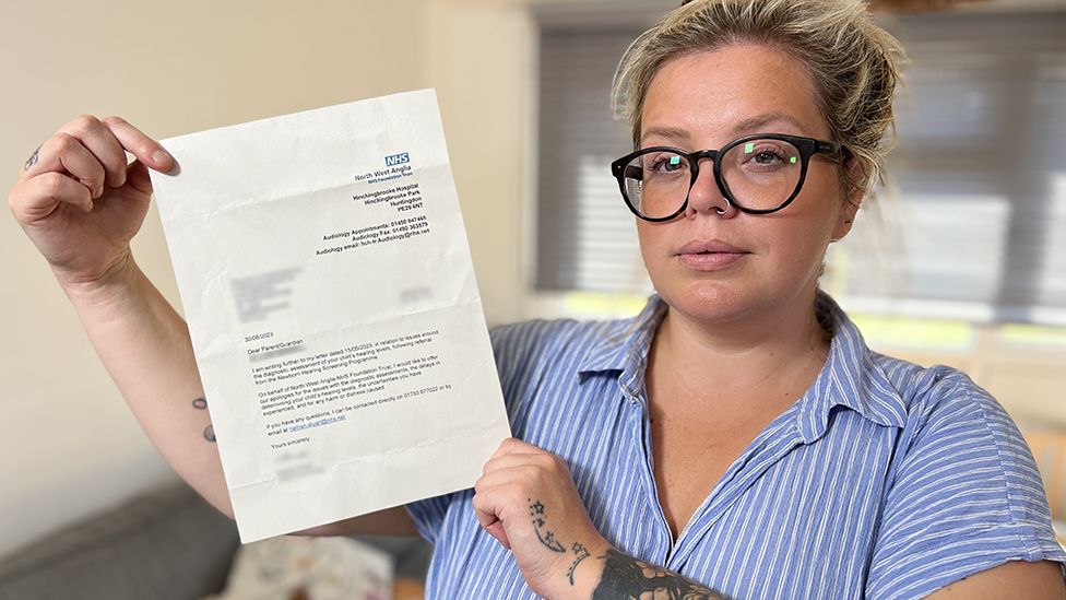 Woman holding up a hospital letter