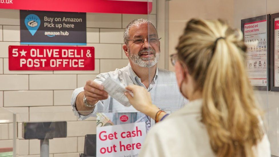 person paying in cash in Post Office