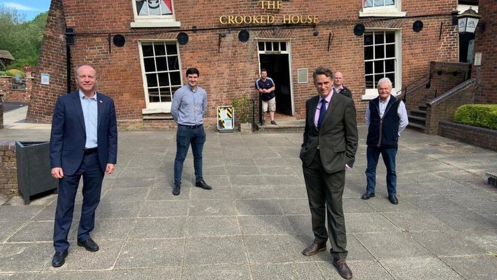 Marco Longhi MP and others standing outside of the crooked house pub