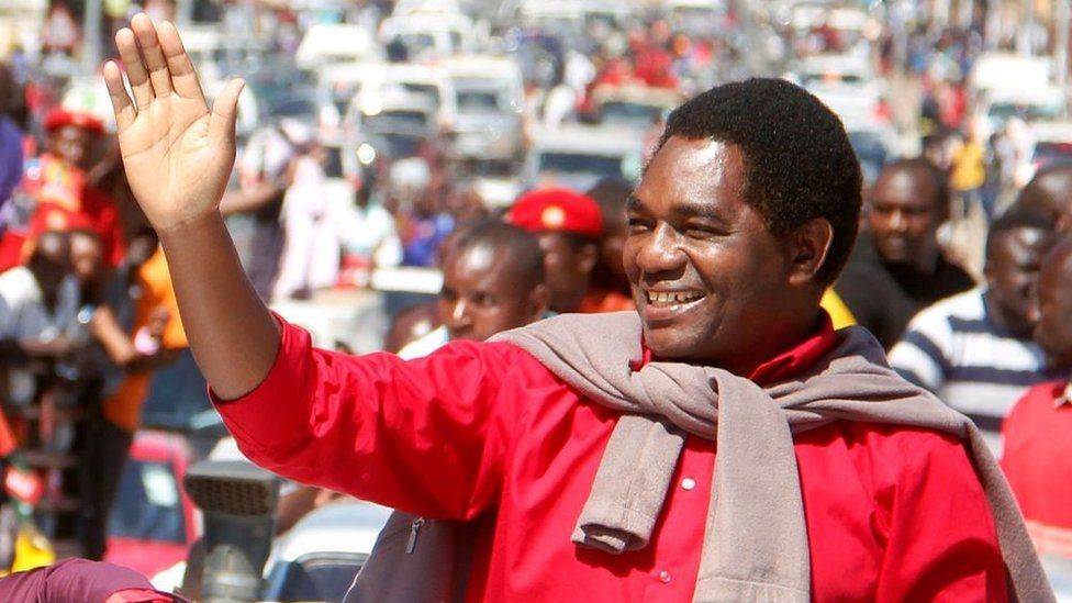 Лидер замбийской оппозиции Хакаинде Хичилема машет своим сторонникам после того, как был освобожден из тюрьмы после того, как обвинение в государственной измене было снято с него 16 августа 2017 года в Лусаке