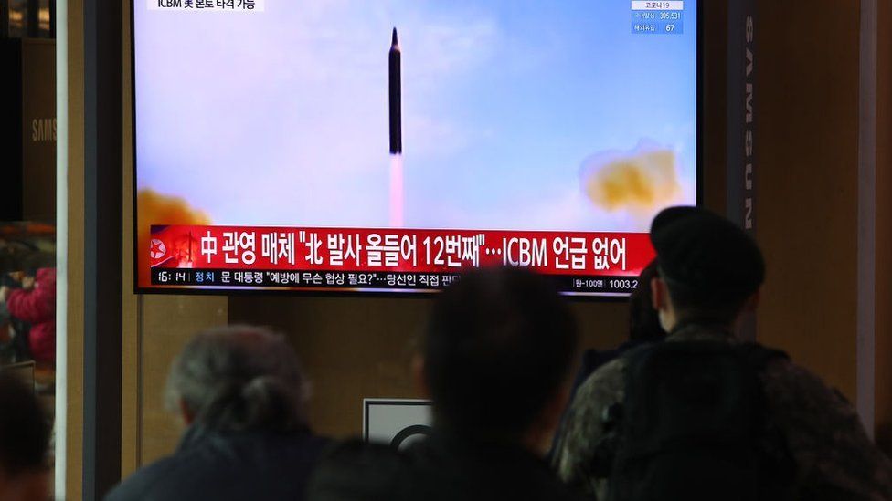 People watch a TV at the Seoul Railway Station showing a file image of a North Korean missile launch on March 24, 2022 in Seoul, South Korea.