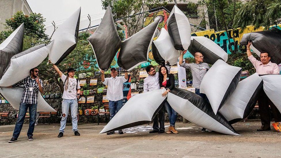 Protesters holding inflatable to represent social leaders killed so far in 2017