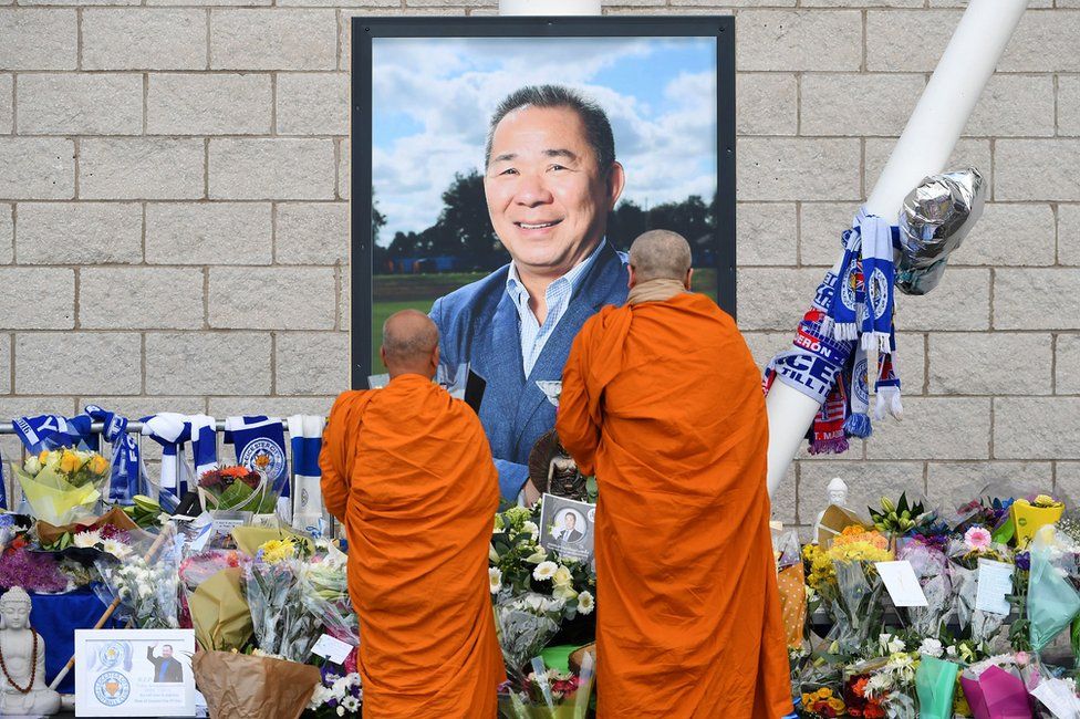 Buddhist monks lay tributes by a photograph of Leicester City Football Club's chairman Vichai Srivaddhanaprabha