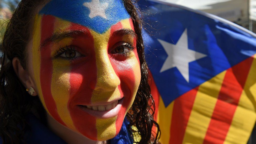 A Catalan demonstrator with her face painted in the pro-independence colours in Barcelona, 11 September
