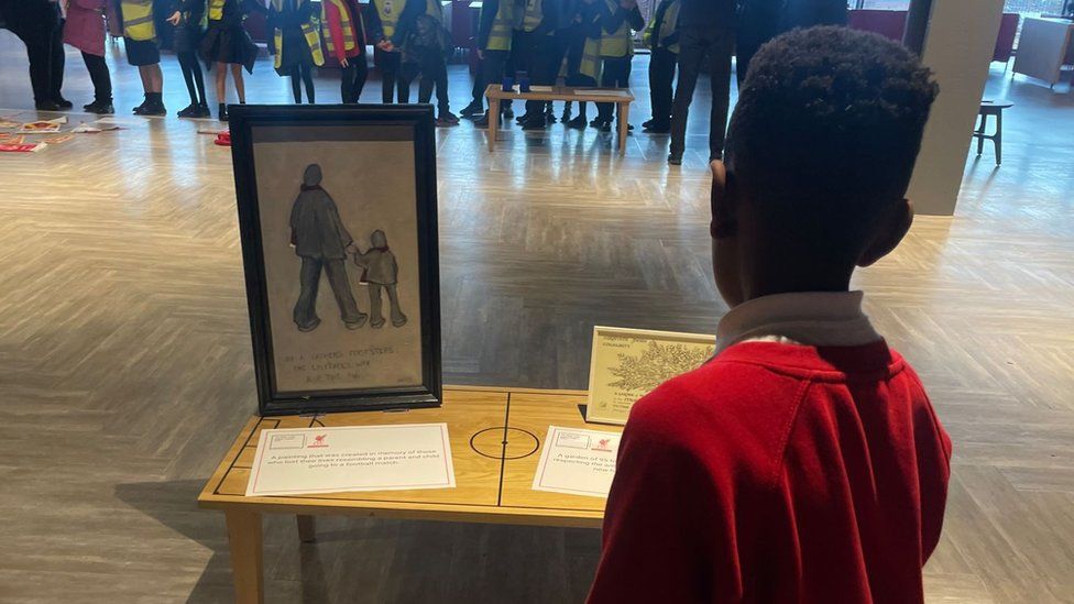 A boy looks at some of the items displayed during a Hillsborough Real Truth Legacy session