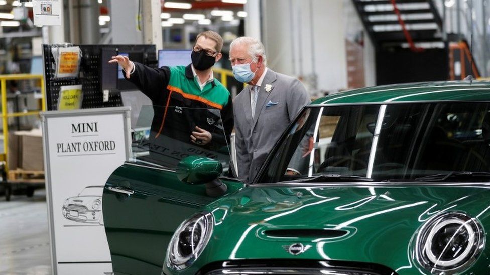 The Prince of Wales speaks to an employee during a visit to the MINI plant in Oxford