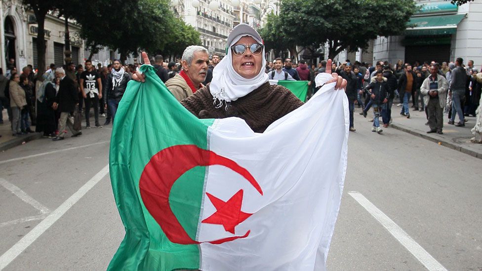 Algerian protesters face security forces during an anti-government demonstration in the capital Algiers on December 12, 2019 during the presidential election