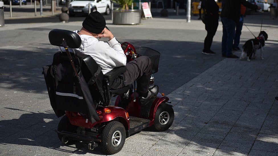 A man sitting on a mobility scooter