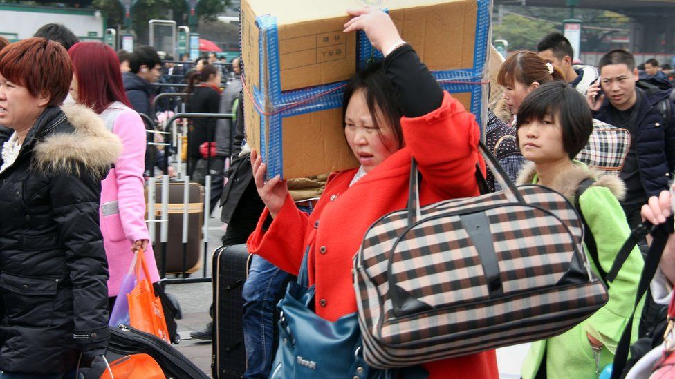Travellers arrive with their bags at a train station
