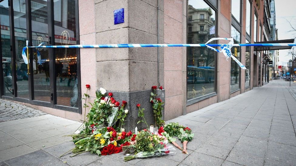 Flowers are pictured on April 8, 2017 at the site where a stolen truck was driven through a crowd and crashed into the Ahlens department store in central Stockholm the day before. The attack on Friday killed four people and injured 15, nine of them seriously
