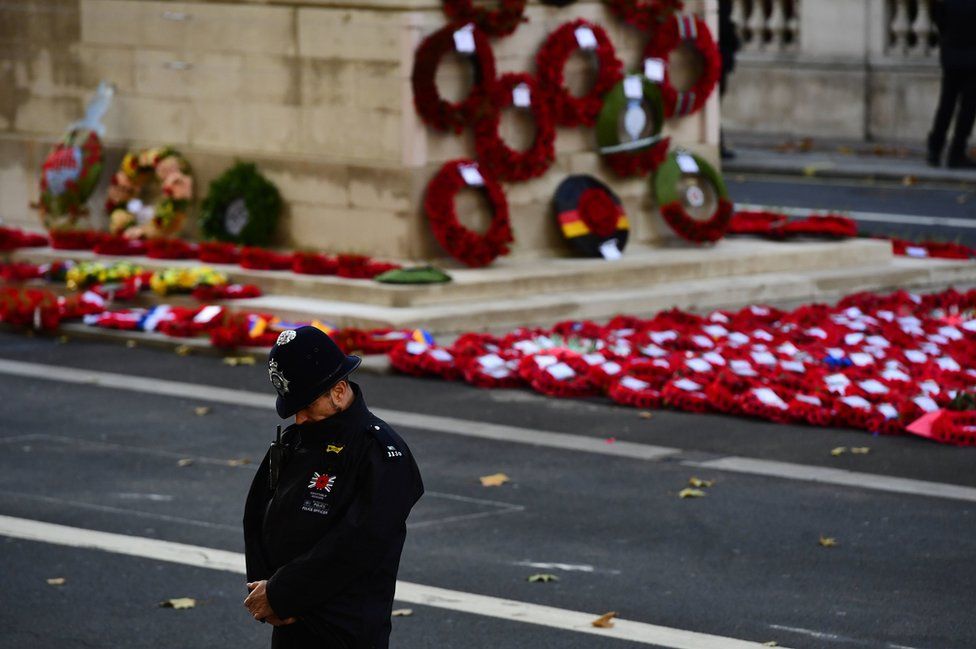 A police officer bows his head during the remembrance service