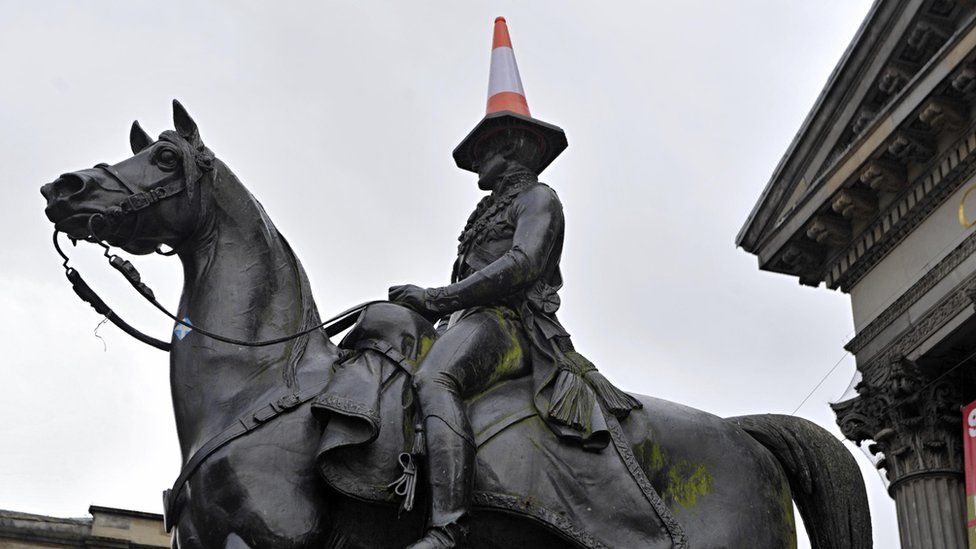 A traffic cone is balanced on the head of a statue of The Duke of Wellington in central Glasgow on November 13, 2013