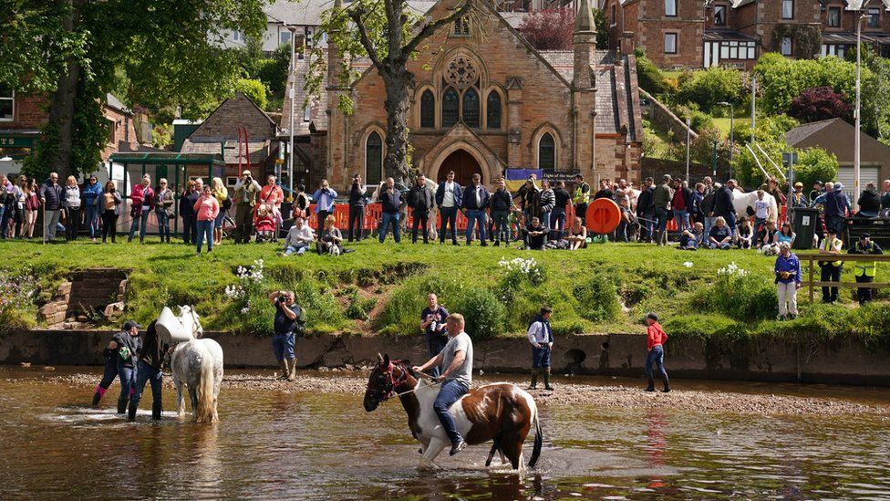 Horses in River Eden while crowd watches