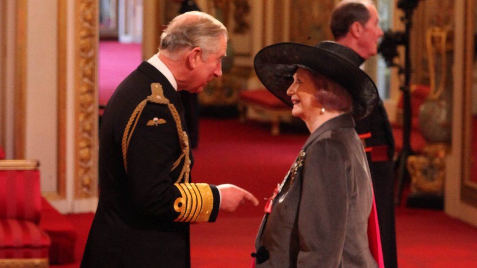 April Ashley being made a Member of the British Empire (MBE) by Prince Charles in 2012