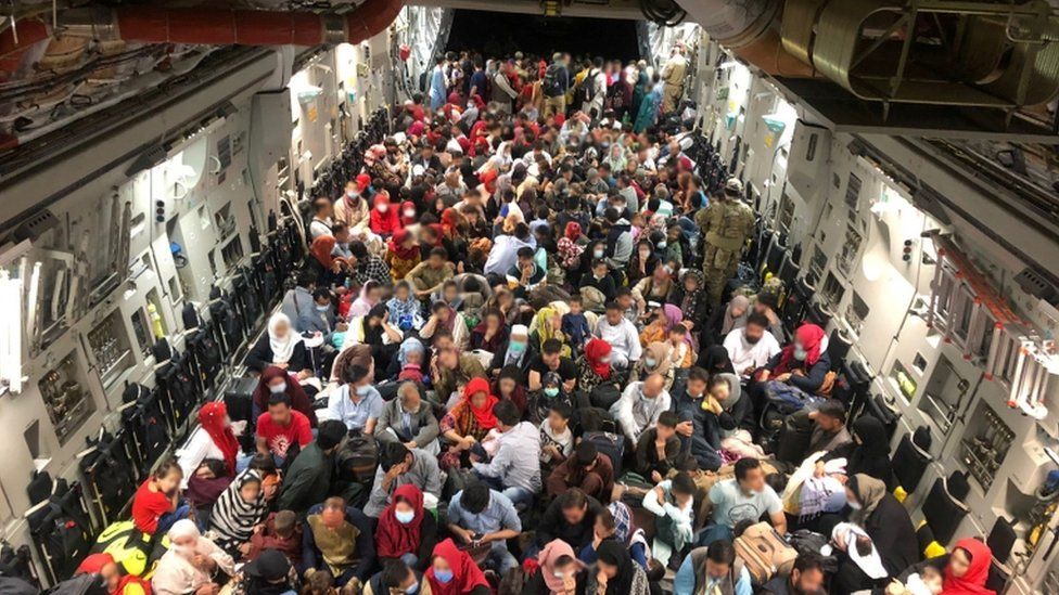 Evacuees sit in an RCAF C-177 Globemaster III transport plane en route to Canada