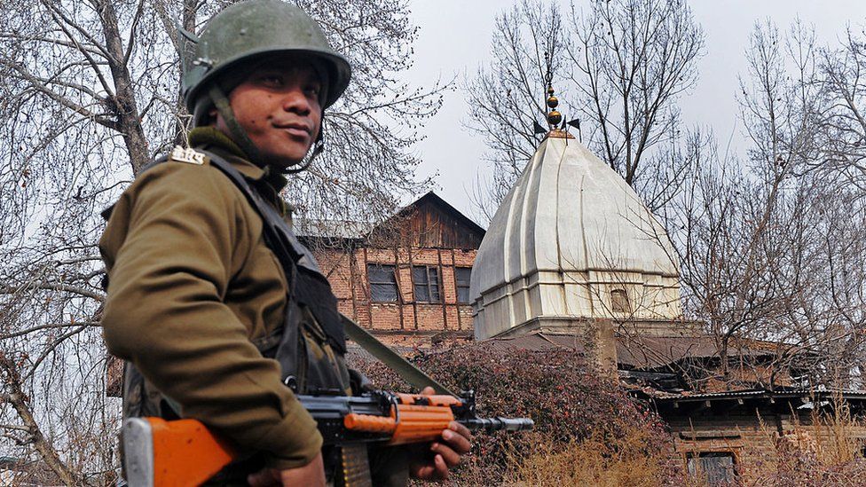 An Indian paramilitary soldier stands guard outside Sheetleshwar Bhairav, one of the valley's oldest and largest Hindu temples, in Srinagar on January 20, 2010 as Kashmiri Pandits perform rituals inside the tempt to mark its re-opening after 21 years.