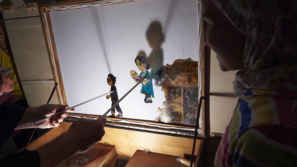 Syrian kids cheer up by the shadow puppetry that animates Syrian children who have fled their country's civil war staged by General Art Director in the Ankara Municipality Theatre, Mehmet Tahir Ikiler on 29 May 2014 in Ankara, Turkey.