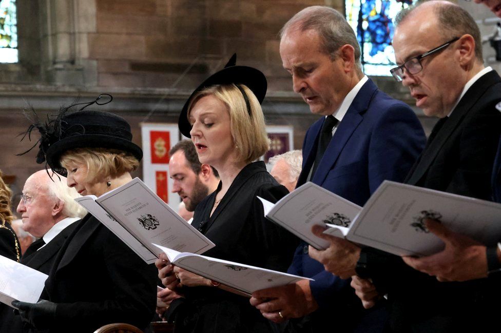 Prime Minister Liz Truss and Taoiseach Micheál Martin sing during the service of reflection for the life of the Queen at St Anne's Cathedral in Belfast